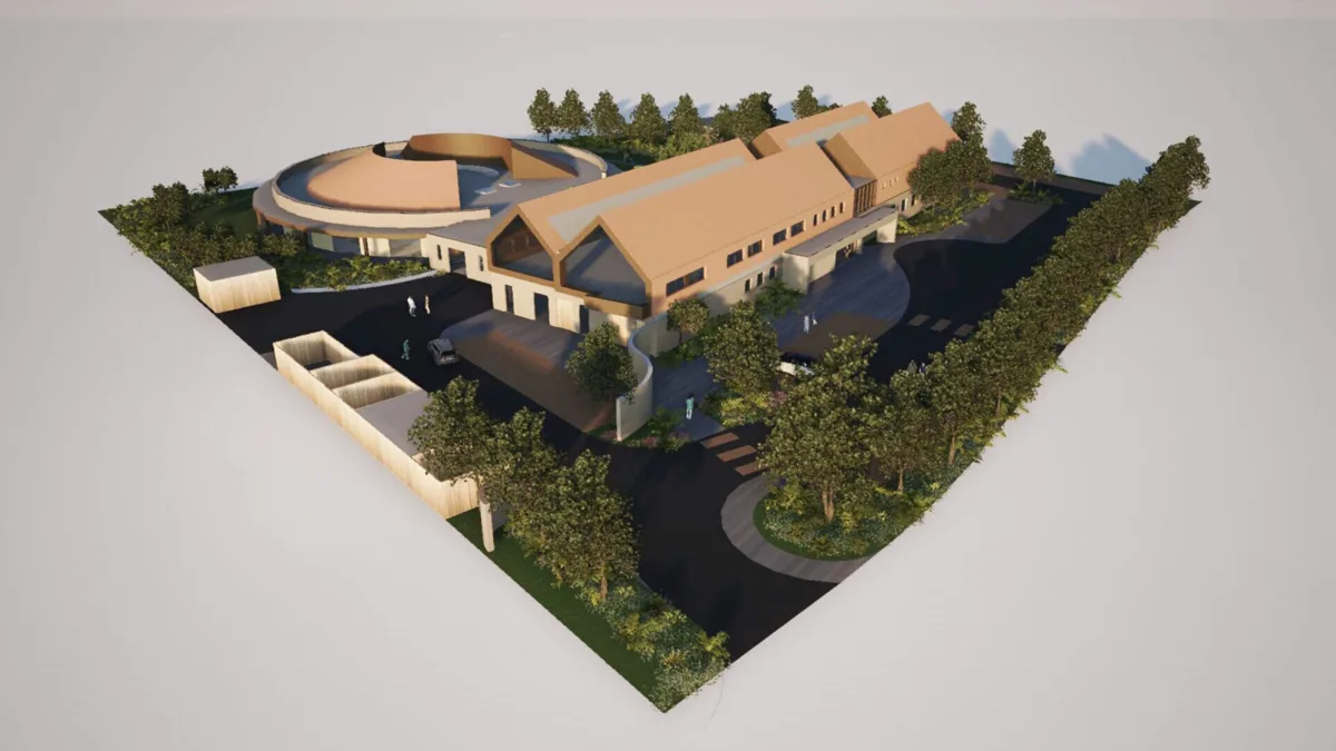 Artist's impression from above of the planned Heart of Kent Hospice at Greensand Place, Linton: a circular wing beside two long pitched-roof wings, with car parking, paths and trees around the site.